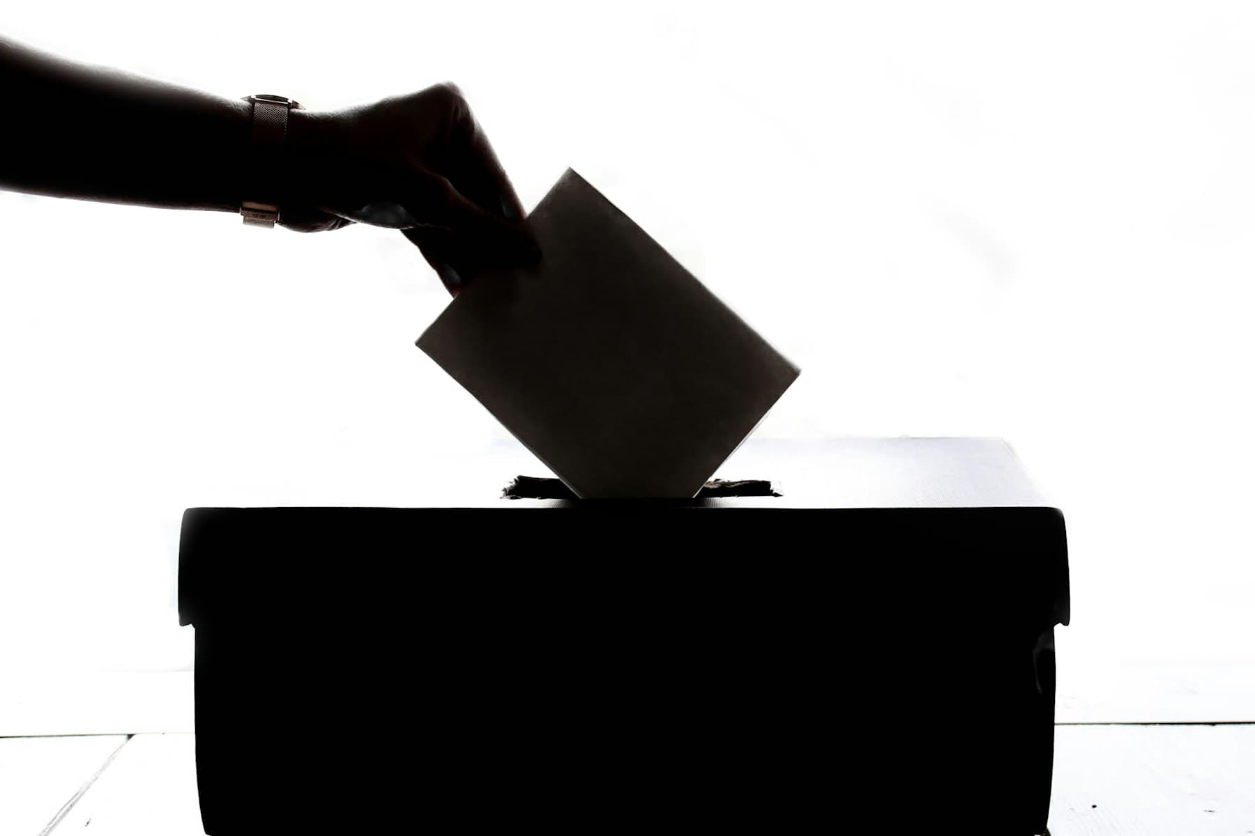 A ballot being dropped into a box