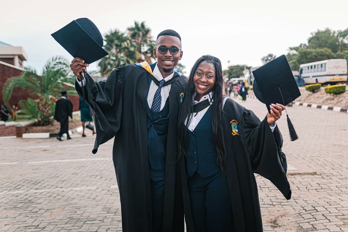 Two graduates celebrating on campus